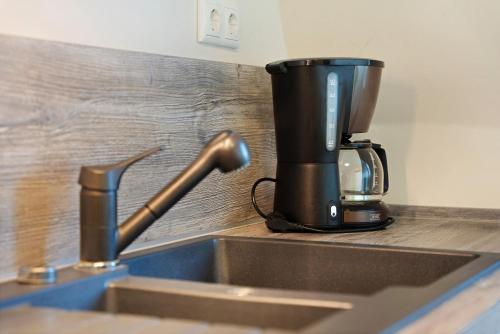 Eine Kaffeemaschine steht auf dem Spülbecken. in der Unterkunft Ferienwohnung Bleichen in Stralsund