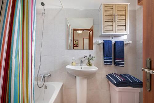 a bathroom with a sink and a toilet and a mirror at Beach House-5 Minutos a pé da praia in Manta Rota