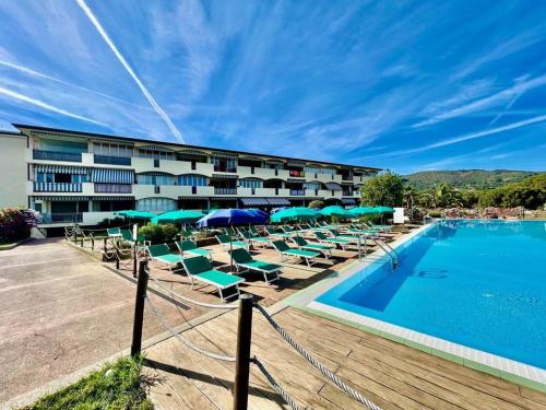 a hotel with a swimming pool with lounge chairs and umbrellas at Casa Verdeblu in Porto Azzurro