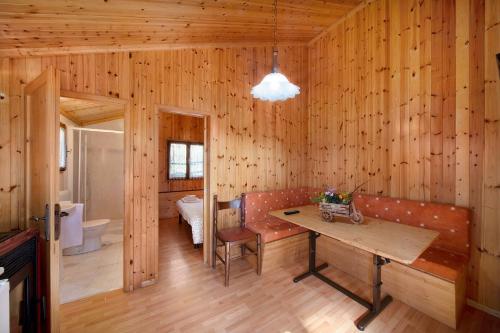 a room with wooden walls and a wooden table and bench at Casa Ciclamino in Barzio