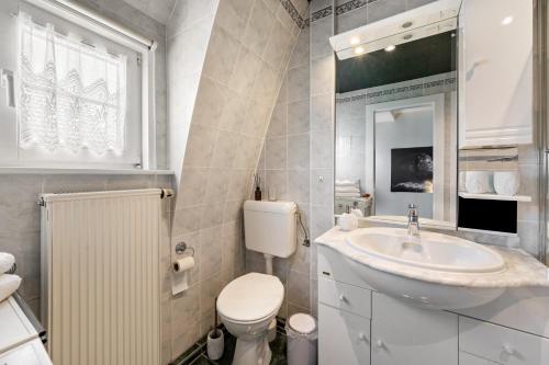 a white bathroom with a sink and a toilet at Carpe Diem - Ferienwohnung in Görlitz