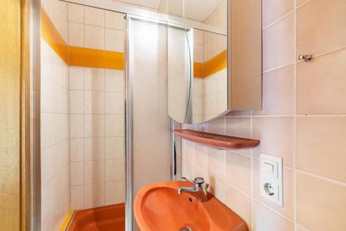 a bathroom with a orange toilet and a mirror at Haus Berger in Seebach