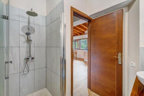 a bathroom with a shower and a wooden door at Complejo Rural Pajar de Bento in Agulo