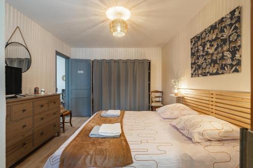 a bedroom with a large bed with a wooden headboard at Maison de vacances centre ville in La Tremblade