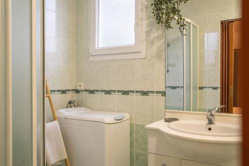 a bathroom with a toilet and a sink at Maison de vacances centre ville in La Tremblade