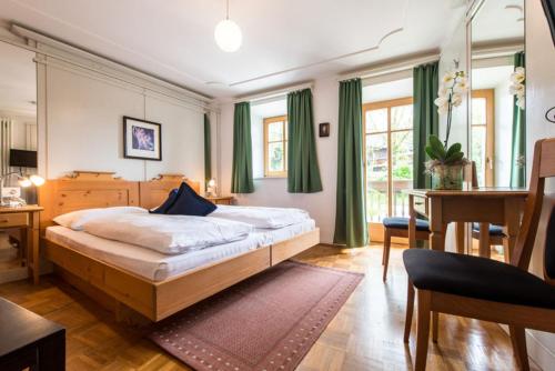 a bedroom with a bed and a desk and a table at Residence Grünbacher in Issengo