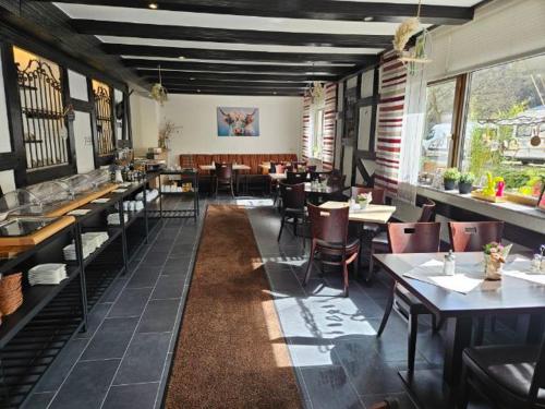 a dining room with tables and chairs in a restaurant at Hotel Alt Cues in Bernkastel-Kues