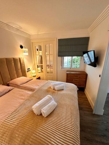 two beds in a bedroom with two towels on them at Parque Miraflores in Mijas