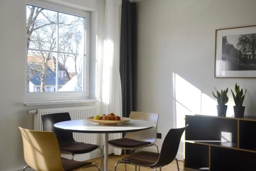 a table and chairs with a bowl of fruit on it at Ferienwohnung An Der Dorfkirche in Vipperow