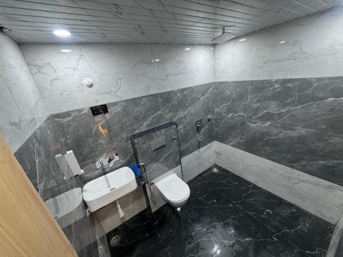 a bathroom with a sink and a toilet at iv hotel Ajmer in Madār