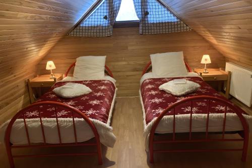 two beds in a small room with two lamps at Chalet les Sonnailles in Mont-Dore
