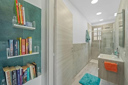 ein Badezimmer mit Dusche und Büchern an der Wand in der Unterkunft Ikigai in Buggerru