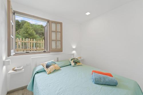 ein Schlafzimmer mit einem Bett mit Kissen und einem Fenster in der Unterkunft Ikigai in Buggerru