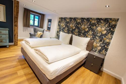 a bedroom with a bed with a floral wall at Michels Mühle - Pitt sin Atelier in Brilon