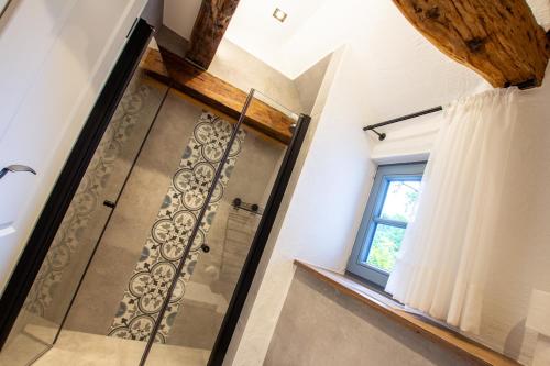 a glass shower in a bathroom with a window at Michels Mühle - Pitt sin Atelier in Brilon