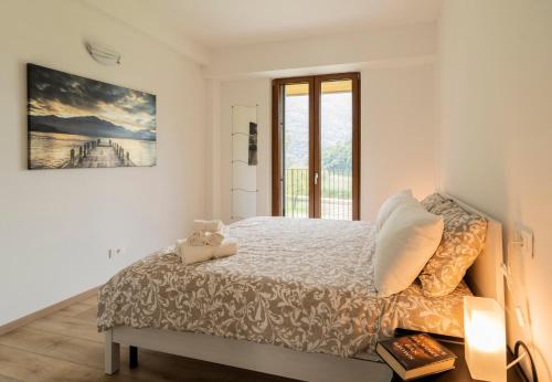 a bedroom with a bed and a large window at Como home residence in Carlazzo