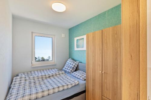 a small bedroom with a bed and a window at Feel Free Apartment in Rheinböllen