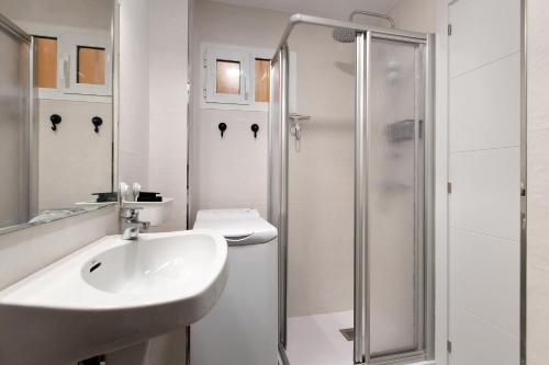 a white bathroom with a sink and a shower at Apartamento Agata 2024 in Benalmádena