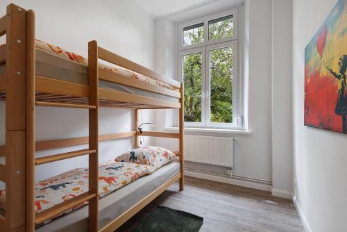 a bedroom with two bunk beds and a window at Reit- und Ferienhof Alte Dorfschule in Holstenniendorf