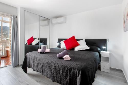 a bedroom with a large bed with red and white pillows at Apartamento Agata 2024 in Benalmádena