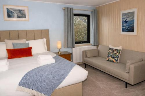 a bedroom with a bed and a couch and a window at The Foveran in Kirkwall