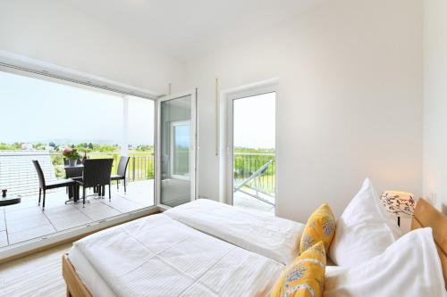 a bedroom with a bed and a balcony at Dinkelbach Feriendomicil 2 C in Lindau-Bodolz