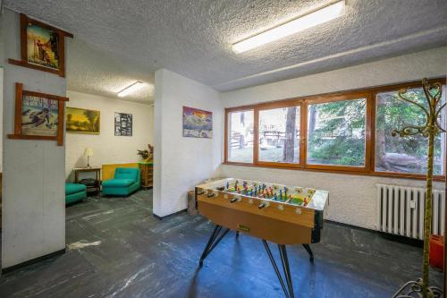 a room with a ping pong table in the middle at Il nido nella Pineta Central in Ski resort - Happy Rentals in Bardonecchia