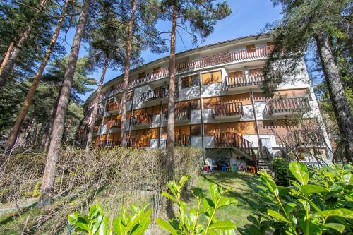an apartment building in the woods with trees at Il nido nella Pineta Central in Ski resort - Happy Rentals in Bardonecchia