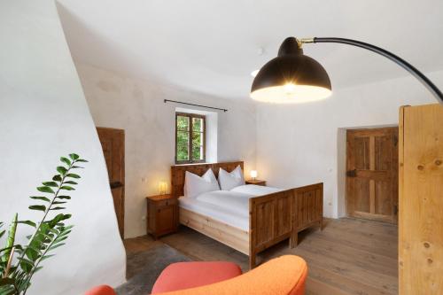 a bedroom with a bed and a chair and a lamp at Ansitz Baumannhof Apt Gotik in Falzes