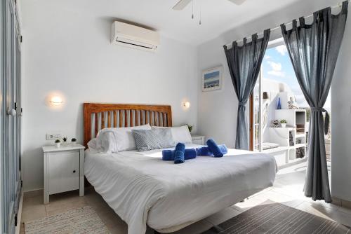 a bedroom with a large bed with blue pillows on it at Puerto Chico T in Playa Blanca