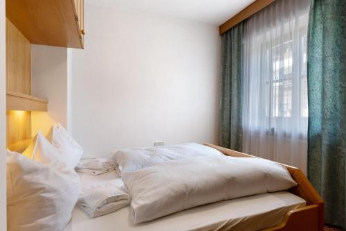 a bedroom with two beds with white pillows and a window at Mayr Apartments Drei in Plaus