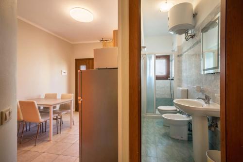a bathroom with a sink and a refrigerator and a table at Appartamento Croce del Sud 8 in Bibione