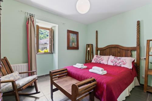 a bedroom with a red bed with two towels on it at Puente del Narcea 4 in Cibuyo