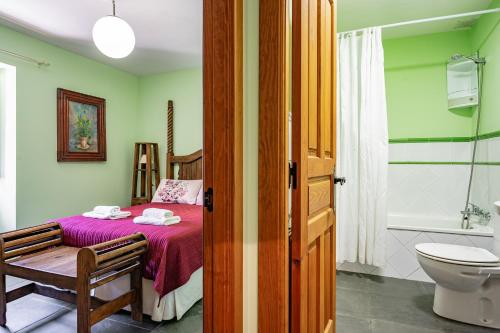 a bedroom with a bed and a bathroom with a toilet at Puente del Narcea 4 in Cibuyo