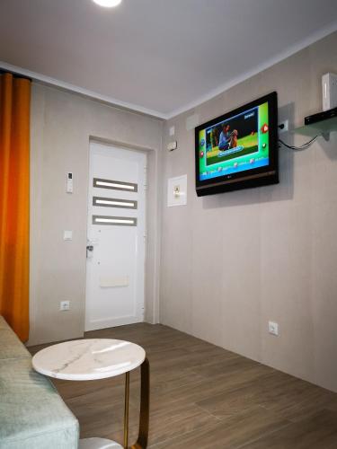 a living room with a tv on a wall at Apartamento ms in Campo Maior