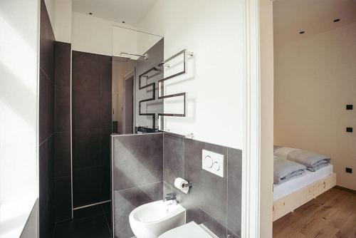 a bathroom with a sink and a toilet and a bed at Freienfeldhof Elstar in Lagundo