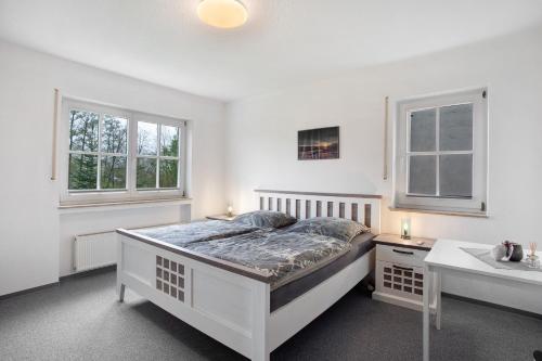 ein weißes Schlafzimmer mit Bett und Waschbecken in der Unterkunft Ferienwohnung Hönneblick in Balve