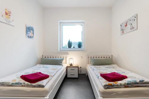 two beds in a room with a window at Speicherhäuschen Maren in Geeste