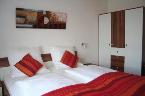 a bedroom with a white bed with red pillows at Apartment für 2, nicht für Monteure in Niederau
