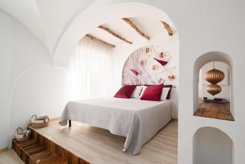 a bedroom with a white bed with red pillows at Giojas125- Monolocale per 2 persone in Orosei