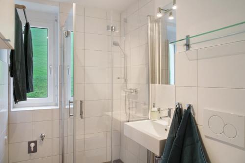 a white bathroom with a sink and a shower at Ferienwohnung Maier - Fontanella in Fontanella
