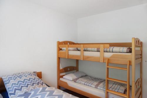 two bunk beds in a room with a bed at Ferienwohnung Maier - Fontanella in Fontanella