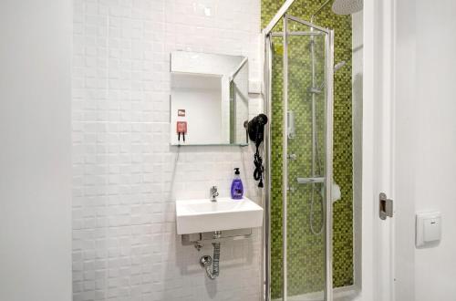 a white bathroom with a sink and a shower at Apartamento nº4 - Beach in Moncarapacho