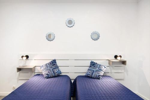 two beds with blue pillows in a room at Apartamento nº4 - Beach in Moncarapacho
