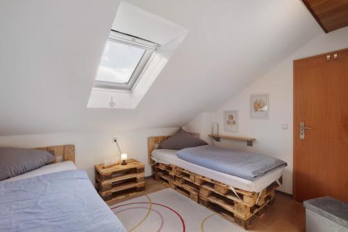 a attic bedroom with two beds and a window at Sara´s Ferienwohnung in Plettenberg