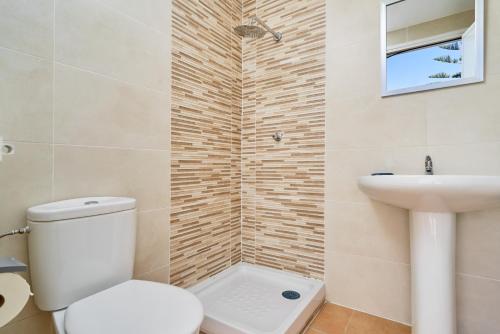 a bathroom with a toilet and a sink at Villa El Peli in Nerja