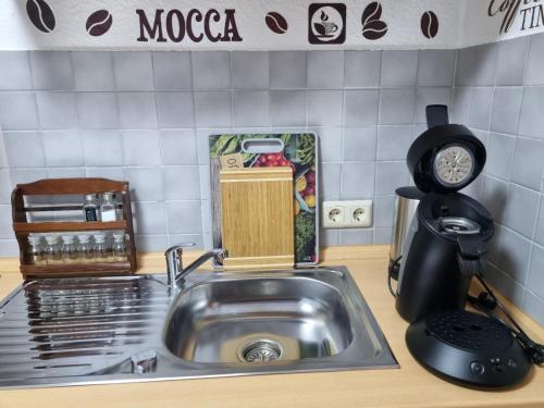 a kitchen counter with a sink and a clock at Ferienwohnung Kuckuck in Ohlsbach