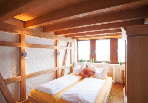 a bedroom with a bed in a room with wooden ceilings at Ferienwohnungen Merkle in Wasserburg