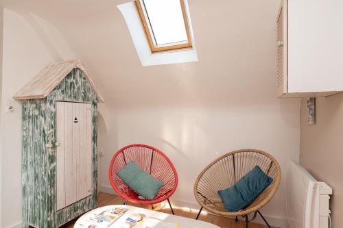 a dining room with two chairs and a bird house at L'idéal, wifi, proche mer et Vannes in Noyalo
