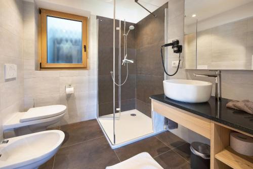a bathroom with a toilet and a sink and a shower at Teutenhofer Kastanie in Feldthurns